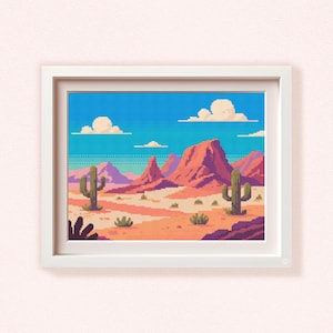 May include: A framed pixel art print depicting a desert landscape with red rock formations, cacti, and a blue sky with clouds. The artwork is framed in a white rectangular frame, showcasing a vibrant and colorful scene.
