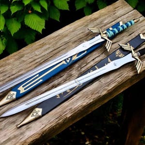 May include: Two decorative swords with silver blades and gold accents rest on a wooden surface. One sword has a blue and gold handle and sheath, while the other has a black sheath and handle. The swords are displayed outdoors.
