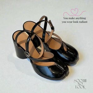 Peut inclure: Paire de sandales à talons noirs en cuir verni, avec un bout arrondi. Les sandales ont un talon bloc épais, des brides de cheville et une fermeture à boucle. Le texte "You make anything you wear look radiant" est visible.