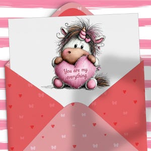 Puede incluir: Una tarjeta de felicitaci&oacute;n con un unicornio de dibujos animados sosteniendo un coraz&oacute;n rosa con el texto "You are my everything". La tarjeta est&aacute; dentro de un sobre rojo con patrones de corazones y mariposas, sobre un fondo rosa a rayas.