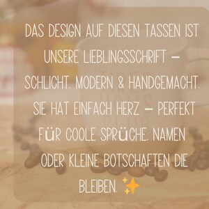 May include: A white ceramic mug with a curved handle, featuring text in German. The text describes the design as simple, modern, and handmade, perfect for cool sayings, names, or small messages. Coffee beans are scattered around the mug.