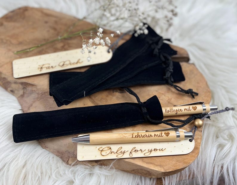 Wichtelgeschenk Kollegin, Kugelschreiber als Geschenk mit Gravur, Personalisierte Kulis, Mitarbeiter Geschenke Weihnachten - zwei Kugelschreiber mit der Gravur "Kollegin mit Herz" und "Lehrerin mit Herz" mit schwarzen Samtsäckchen als Verpackung. Dabei liegen noch zwei Lesezeichen mit Gravur "Für Dich" und "Only for you".