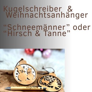 May include: Wooden Christmas ornaments with snowman and deer designs, paired with engraved pens. The pens read "Kollegin mit" and "Lehrerin mit". The ornaments and pens are set on a wooden surface, ideal for holiday gifting.