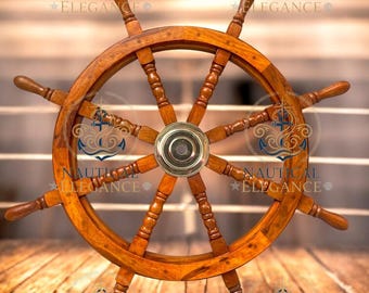 May include: A wooden ship's wheel with eight spokes and a brass centre. The wheel is a warm brown colour and sits against a blurred wooden background. The words "NAUTICAL ELEGANCE" are stamped on the image.