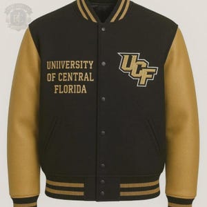 Puede incluir: Una chaqueta universitaria negra con mangas doradas, que presenta el texto UNIVERSITY OF CENTRAL FLORIDA y el logotipo de UCF bordados en dorado en el pecho. La chaqueta tiene cierre frontal de botones a presión y ribetes a rayas en cuello y puños.