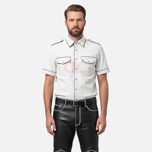 May include: White short-sleeved shirt with black trim and two chest pockets. The shirt is paired with black leather trousers with white stitching and a black belt. The outfit is a modern take on a classic style.