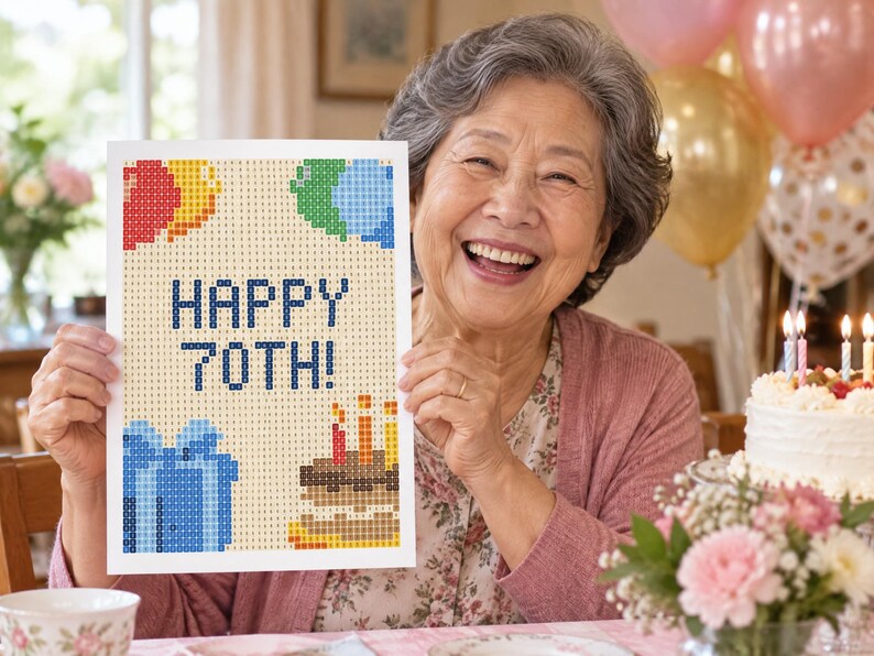 May include: A rectangular diamond painting craft project featuring a beige background with a pixelated design of colorful balloons, a blue gift box, a birthday cake with lit candles, and the dark blue text that reads HAPPY 70TH!