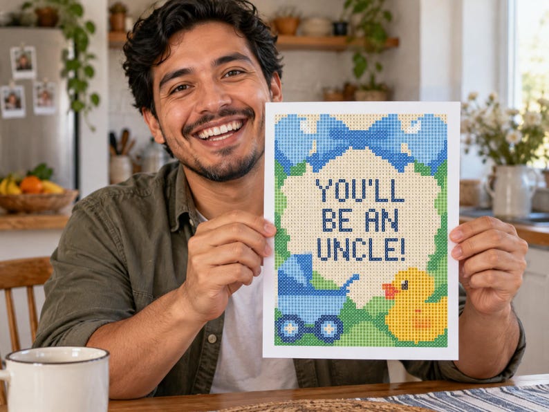 Peut inclure: Une impression rectangulaire pr&eacute;sentant un motif pix&eacute;lis&eacute; avec le texte "YOU'LL BE AN UNCLE!" en bleu fonc&eacute;. L'illustration comprend un grand n&oelig;ud bleu en haut, une poussette bleue &agrave; gauche et un canard en caoutchouc jaune &agrave; droite, le tout sur un fond vert avec une bulle centrale de couleur cr&egrave;me.