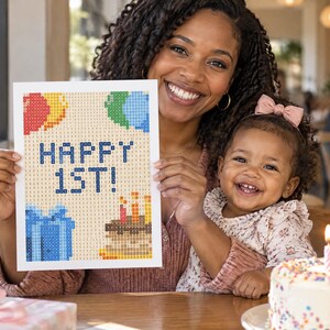 Puede incluir: Un proyecto de manualidades de pintura de diamantes rectangular con un diseño pixelado que muestra el texto HAPPY 1ST! en azul, acompañado de globos coloridos, una caja de regalo azul y un pastel de cumpleaños con tres velas encendidas.