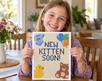 Könnte beinhalten: Ein rechteckiges Schild mit einem Pixel-Art-Design und dem Text NEW KITTEN SOON! in Dunkelblau. Das Motiv zeigt eine blaue Wolke, blaue und orangefarbene Luftballons, eine gelbe Quietscheente und einen braunen Teddybären auf hellem Grund.