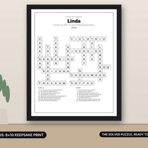 May include: A framed retirement crossword puzzle print titled Linda, dated October 30, 2026, featuring 32 years at Riverside Elementary. The black and white grid includes clues for across and down, with the text Bonus: 8x10 Keepsake Print and The Solved Puzzle, Ready to Frame.
