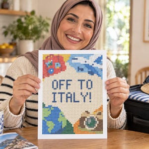 May include: A rectangular diamond painting craft project featuring the text OFF TO ITALY! in dark blue letters. The design includes colorful pixelated illustrations of a red car, a blue airplane, a globe, and a camera on a light background.