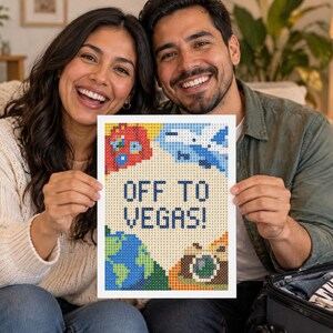 May include: A rectangular diamond painting craft project featuring a pixelated design with the text OFF TO VEGAS! in dark blue. The artwork includes colorful icons of a red suitcase, a blue airplane, a globe, and a camera on a light background.