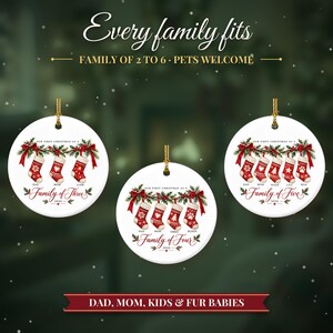 May include: Three round white ceramic ornaments featuring red and white Christmas stockings hanging from a green garland with red bows. Text includes "Every family fits", "Family of three", "Family of four", "Family of five", and "2026".
