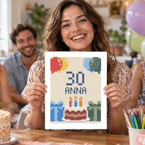May include: A rectangular white card featuring a pixelated cross-stitch design of a birthday celebration. The center displays the number 30 and the name Anna in blue text, surrounded by colorful balloons, two wrapped gift boxes, and a birthday cake.