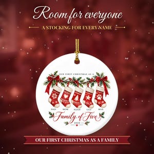 May include: A round white ceramic ornament featuring a gold hanging cord. The design shows five red and white Christmas stockings hanging from a holly branch with red bows. Text reads: Room for everyone, A STOCKING FOR EVERY NAME, OUR FIRST CHRISTMAS AS A Family of Five, 2026, DAD, MOM, NOAH, LILY, MAX, OUR FIRST CHRISTMAS AS A FAMILY.