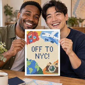 May include: A rectangular diamond painting craft project featuring the text OFF TO NYC! in dark blue pixels. The design includes a red suitcase, a blue airplane, a green and blue globe, and a brown camera, all rendered in a colorful pixelated style.