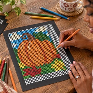 May include: A dot-to-dot coloring activity sheet featuring a large orange pumpkin with a brown stem, green leaves, and red autumn foliage against a blue sky with white clouds, printed on black paper with white circular outlines for coloring.