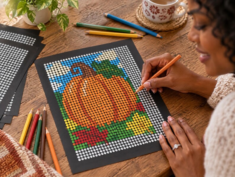 May include: A dot-to-dot coloring activity sheet featuring a large orange pumpkin with a brown stem, green leaves, and red autumn foliage against a blue sky with white clouds, printed on black paper with white circular outlines for coloring.