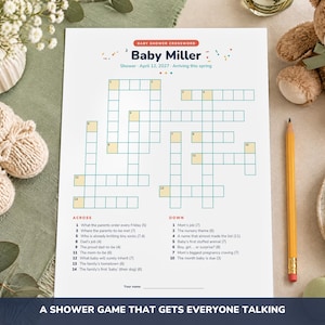 May include: A white paper baby shower crossword game titled Baby Miller with the date April 12, 2027. The game features numbered clues for across and down sections, a blank line for a name, and a grid of empty boxes for filling in answers.