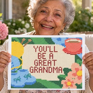 Puede incluir: Una manualidad de pintura de diamantes rectangular con el texto YOU'LL BE A GREAT GRANDMA en letras rojo oscuro. El diseño incluye un ovillo de lana amarillo con agujas de tejer, patucos azules, una taza roja y flores rosas sobre un fondo claro.