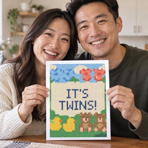 May include: A rectangular diamond painting craft project featuring a pixelated design with the text IT'S TWINS! in dark blue. The image includes two red baby onesies, two brown teddy bears, and two yellow rubber ducks against a green background.