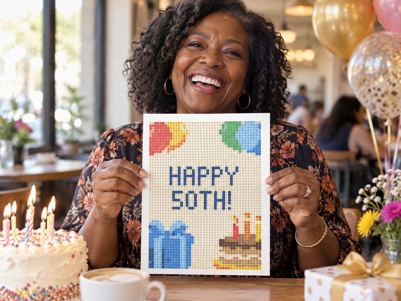 May include: A rectangular white sign featuring a pixelated design with the text HAPPY 50TH! in dark blue. The graphic includes colorful balloons in red, yellow, and blue, a blue gift box, and a brown birthday cake with three lit candles.