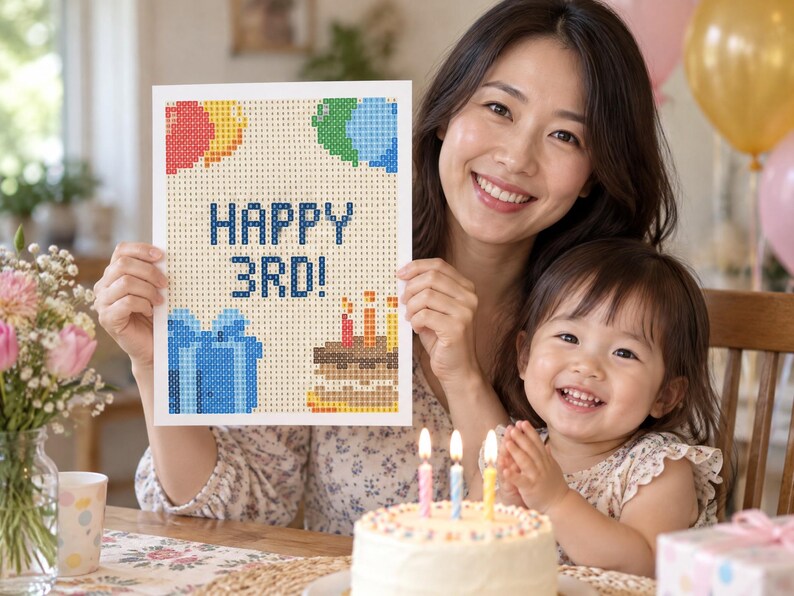 Puede incluir: Un proyecto de manualidades de diamond painting rectangular con un dise&ntilde;o pixelado que incluye el texto HAPPY 3RD! en azul, acompa&ntilde;ado de globos de colores, una caja de regalo azul y un pastel de cumplea&ntilde;os con tres velas encendidas sobre fondo blanco.