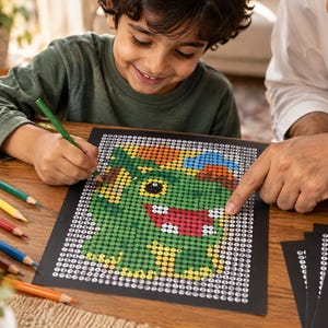 K&ouml;nnte beinhalten: Ein Malen-nach-Zahlen-Arbeitsblatt mit einer gr&uuml;nen Dinosaurier-Illustration auf schwarzem Hintergrund mit nummerierten Kreisen. Das Blatt wird von einem Set Buntstifte in einem Holzhalter und weiteren leeren Arbeitsbl&auml;ttern begleitet.
