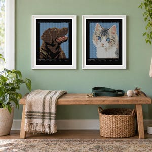 May include: Two framed wall art prints featuring pixelated portraits of a brown dog and a multi-colored cat. Each print is set against a blue patterned background within a black border, displayed in white frames on a sage green wall.