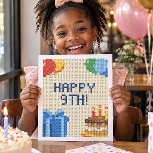 May include: A rectangular diamond painting craft project featuring a pixelated design with the text HAPPY 9TH! in blue, accompanied by illustrations of colorful balloons, a blue gift box, and a birthday cake with three lit candles.