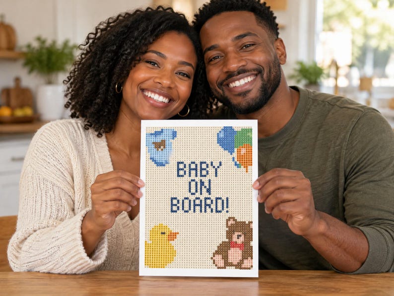May include: A rectangular sign featuring a pixel art design on a light beige background. The text reads BABY ON BOARD! in dark blue. The design includes a blue baby onesie, a cluster of blue, green, and orange balloons, a yellow rubber duck, and a brown teddy bear.