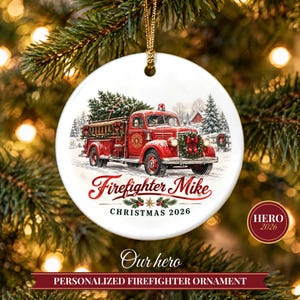May include: A round white ceramic ornament featuring a red vintage fire truck carrying a Christmas tree. The text reads Firefighter Mike and CHRISTMAS 2026. The ornament hangs from a gold cord against a blurred green pine tree background.