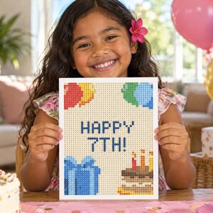 Puede incluir: Un proyecto de manualidades de diamond painting rectangular con un patr&oacute;n de cuadr&iacute;cula y el texto HAPPY 7TH! en azul, rodeado de ilustraciones pixeladas de globos coloridos, una caja de regalo azul y un pastel con velas encendidas.