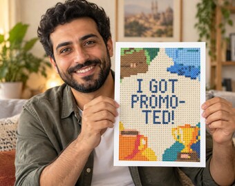 Könnte beinhalten: Ein rechteckiger Druck mit einem Pixel-Art-Design und dem Text I GOT PROMOTED! in Dunkelblau. Das Kunstwerk zeigt einen goldenen Pokal, eine braune Kaffeetasse sowie abstrakte blaue und braune Formen auf einem hellen cremefarbenen Hintergrund.