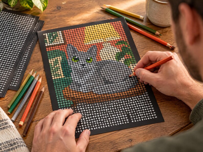 May include: A color-by-number activity sheet featuring a gray cat with green eyes sitting indoors. The image is composed of small numbered circles on a black background, with a partially colored section showing the cat, a lamp, and foliage.