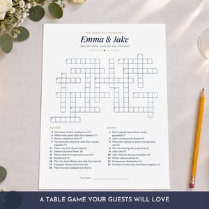 May include: A white rectangular wedding crossword puzzle game sheet titled Emma & Jake, dated June 20, 2026, at Lakeside Inn, Vermont. The paper features a grid of empty boxes for answers, with numbered clues listed below for across and down categories.