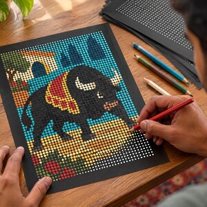 May include: A dot-to-dot coloring page on black paper featuring a black bull with a red and yellow patterned blanket on its back. The bull stands on a yellow ground with a blue sky and a small building in the background. A red pencil is being used.