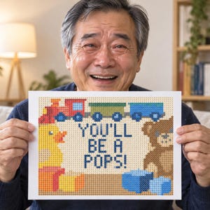 Pu&ograve; includere: Una stampa rettangolare con un design in pixel art che mostra un treno rosso, una papera di gomma gialla e un orsacchiotto marrone. Il testo centrale recita YOU'LL BE A POPS! in lettere blu pixelate, circondato da blocchi colorati.