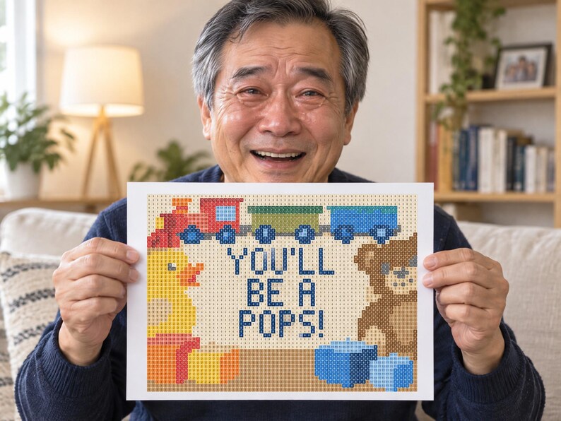 Pu&ograve; includere: Una stampa rettangolare con un design in pixel art che mostra un treno rosso, una papera di gomma gialla e un orsacchiotto marrone. Il testo centrale recita YOU'LL BE A POPS! in lettere blu pixelate, circondato da blocchi colorati.