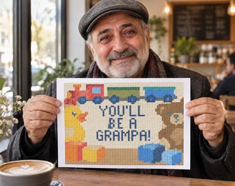 May include: A rectangular white sign featuring a pixel art design of a red train, a yellow rubber duck, and a brown teddy bear. The text in the centre of the sign reads, "YOU'LL BE A GRAMPA!" in dark blue pixelated letters, surrounded by colourful blocks.