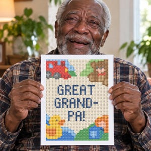 Pu&ograve; includere: Un progetto artigianale rettangolare con un design pixelato su sfondo bianco. Il testo GREAT GRAND-PA! &egrave; centrato in blu. Attorno al testo ci sono piccole immagini pixelate di un treno rosso, un orso marrone, un'anatra gialla e blocchi blu.