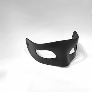 Puede incluir: Una m&aacute;scara de cuero negro para masquerade con un solo agujero para el ojo.