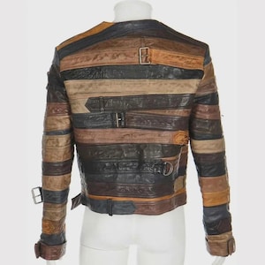 Puede incluir: Chaqueta de cuero multicolor con tiras horizontales en tonos marr&oacute;n, negro y beige. La chaqueta tiene m&uacute;ltiples hebillas y correas. Se muestra la vista trasera de la chaqueta.