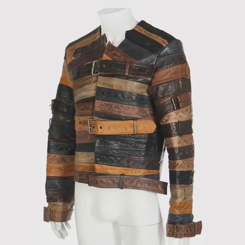 Puede incluir: Una chaqueta de cuero patchwork en tonos marr&oacute;n, negro y beige. La chaqueta presenta tiras horizontales de cuero, aseguradas con m&uacute;ltiples cierres de hebilla. Las mangas tienen detalles de hebilla en los pu&ntilde;os. La chaqueta se exhibe en un maniqu&iacute;.