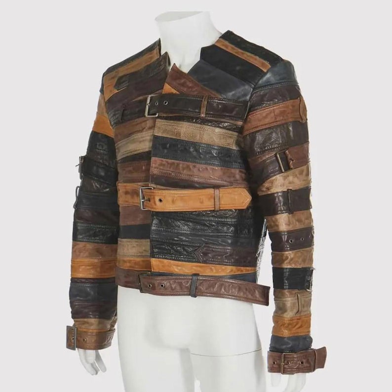 Puede incluir: Chaqueta de cuero patchwork en tonos marr&oacute;n, negro y beige. La chaqueta presenta tiras horizontales de cuero con cierres de hebilla y cinturones. Las mangas y los paneles frontales est&aacute;n detallados con m&uacute;ltiples cinturones y hebillas, creando un dise&ntilde;o &uacute;nico.