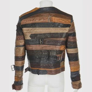Puede incluir: Chaqueta de cuero multicolor con tiras horizontales en tonos marr&oacute;n, negro y beige. La chaqueta tiene m&uacute;ltiples hebillas y correas. Se muestra la vista trasera de la chaqueta.