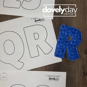 May include: A blue fabric letter R with a polka dot pattern placed next to printed paper templates of uppercase letters and numbers. The templates feature the text 5 inch Uppercase Letters, 1 inch size reference, and the logo dovelyday CREATIVE.