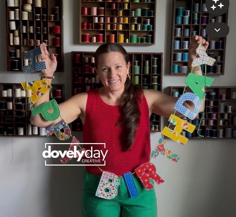 May include: A fabric birthday banner featuring individual letters in various colorful patterns and solid colors, strung together on a thin cord. The banner spells out the word birthday with each letter crafted from different textiles and textures.