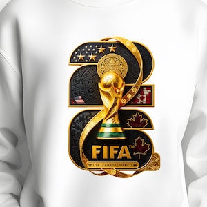 May include: A white sweatshirt featuring a large graphic of the number 26 in gold and black. The design incorporates the FIFA World Cup trophy, a sun calendar, stars, a maple leaf, and the text FIFA USA | CANADA | MEXICO in gold lettering.